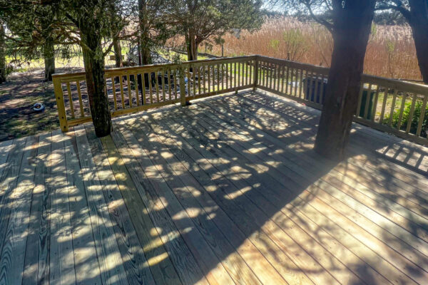 Waterfront pressure-treated wood deck with custom matching wood railings and pickets - North Carolina