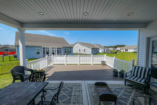 Professional deck builder installing premium Trex composite decking with hidden fasteners and custom white railings.