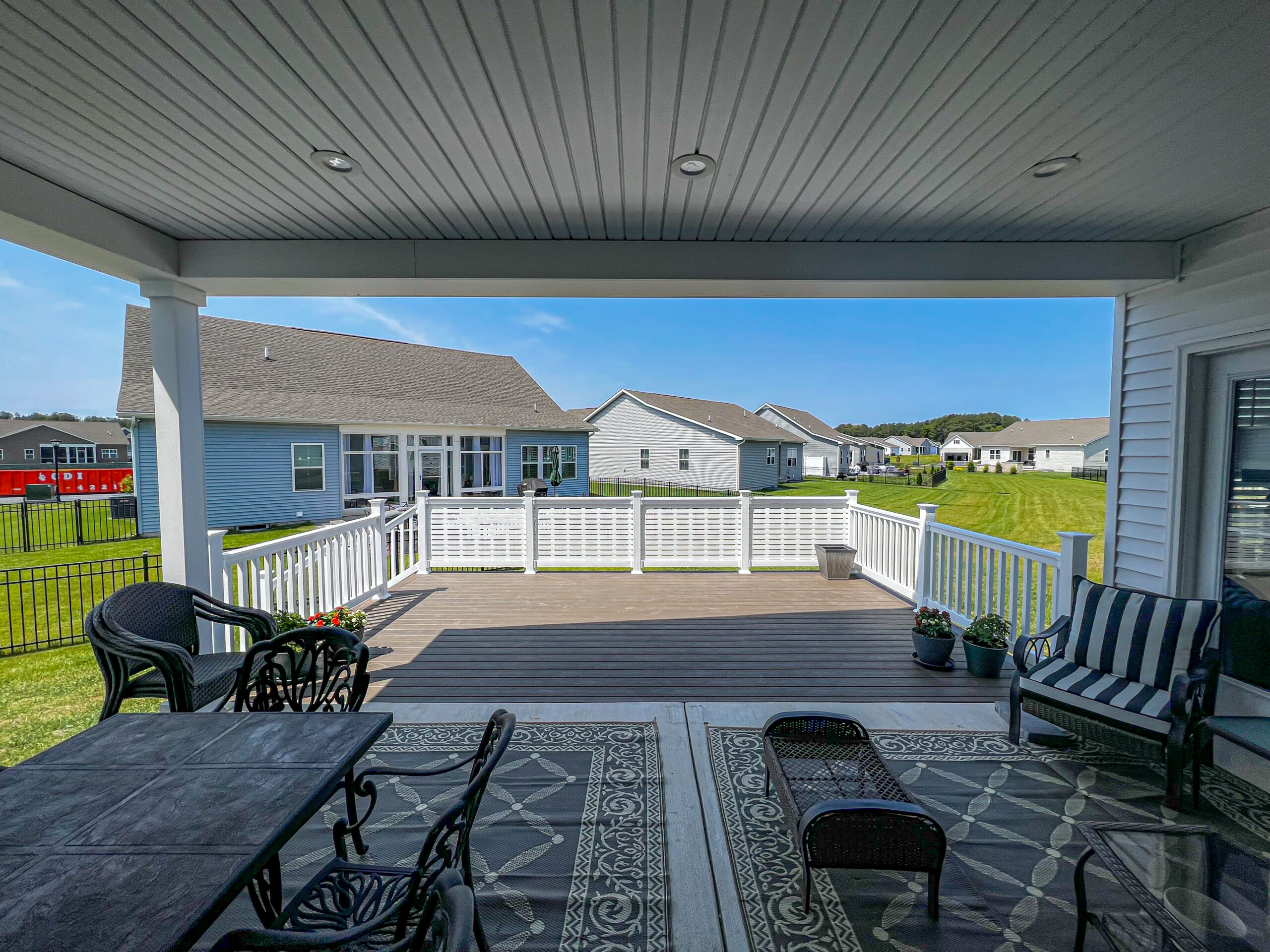 Professional deck builder installing premium Trex composite decking with hidden fasteners and custom white railings.