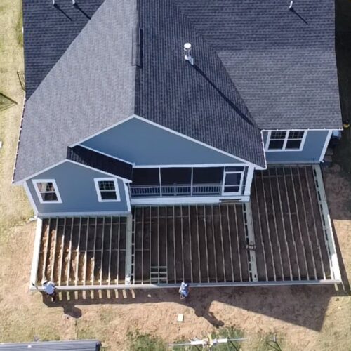 Aerial drone view of a large residential deck under construction, showing professional joist framing and structural layout.