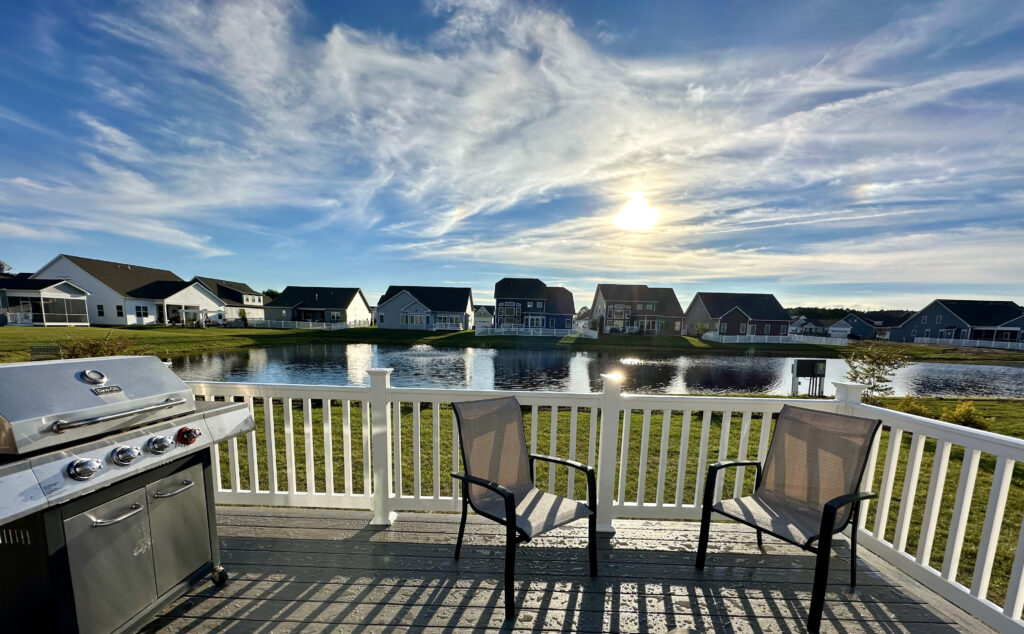 Elevated Trex composite deck with white railings and a stainless steel grill overlooking a North Carolina residential neighborhood.