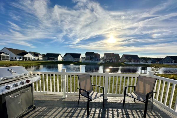 Elevated Trex composite deck with white railings and a stainless steel grill overlooking a North Carolina residential neighborhood.
