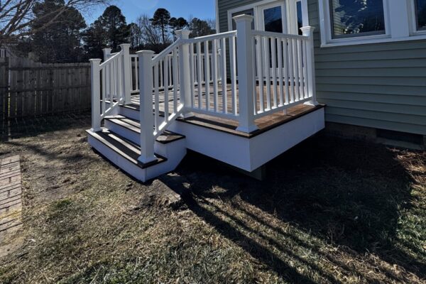 Completed custom composite deck in Fuquay-Varina, NC, featuring white railings and wide stairs by Titan Decks.