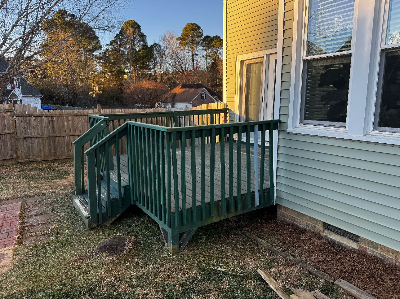 Old wood deck with green algae growth and peeling stain in Fuquay-Varina, NC, before a composite deck upgrade.