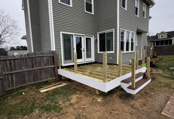 Professional deck framing and construction in Fuquay-Varina, NC, showing structural joists for a new composite deck.