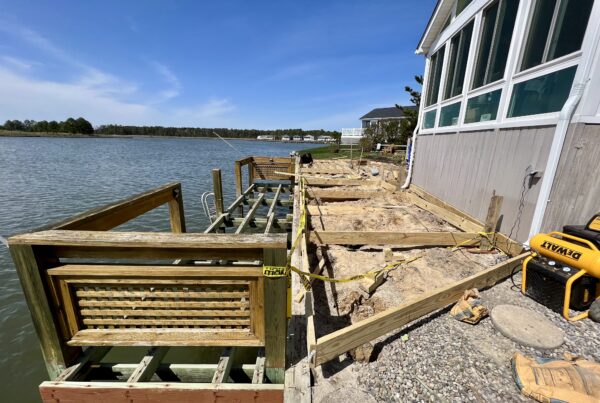 Active construction of a custom wood deck frame showing joist spacing and structural headers by Titan Decks in North Carolina.