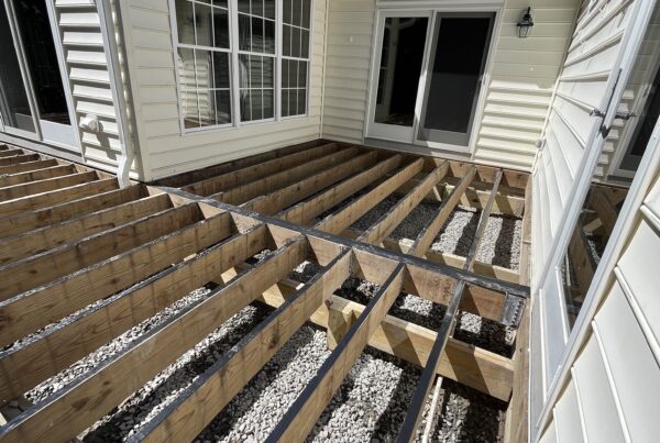 Close-up of waterproof butyl joist tape being applied to a wood deck frame during a composite resurfacing project by Titan Decks.