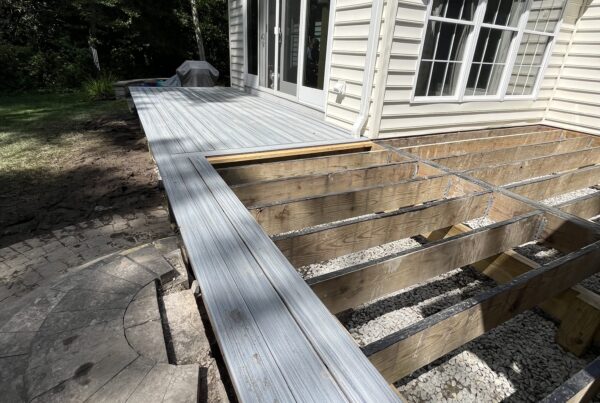 Close-up of new composite deck boards being installed over a waterproofed frame during a Titan Decks resurfacing project.