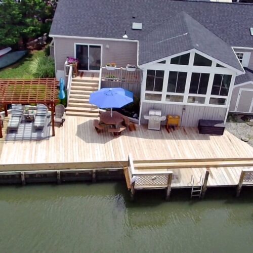 Aerial-Waterfront-Wood-Deck-Build-NC erial view of a completed custom wood deck, pergola, and waterfront dock in North Carolina by Titan Decks.