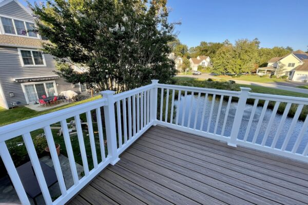 After photo of a Trex Transcend Havana Gold deck resurface with a custom dark brown picture-frame border and white vinyl railings.