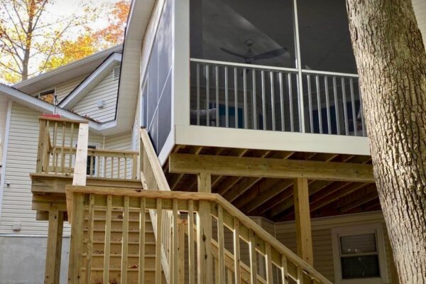 Side view of custom wood stairs leading to an elevated screened-in porch in North Carolina by Titan Decks.
