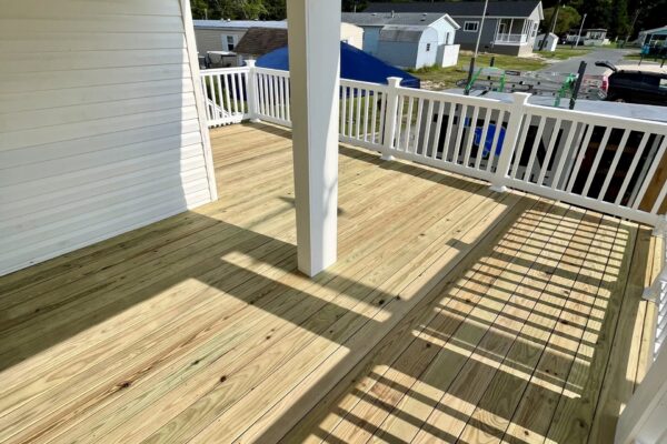 Sunlight filtering through a new wood deck and porch structure built by Titan Decks in North Carolina.