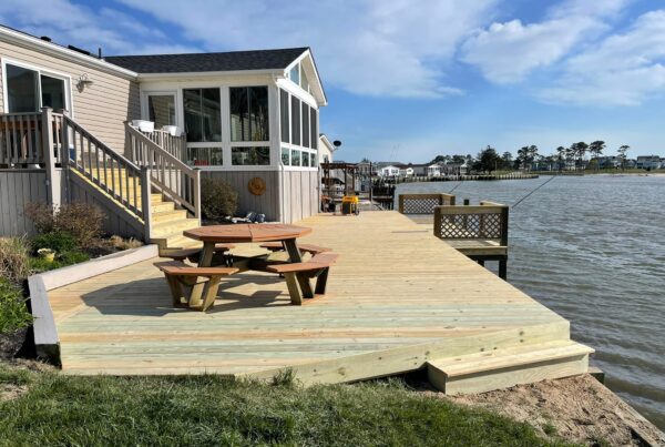 Completed wide wood deck and dock area with a picnic table on a North Carolina waterfront by Titan Decks.