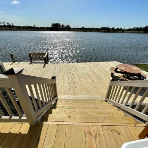 Wood-Deck-Stairs-Waterfront-NC View from the stairs of a completed wood deck and lakefront dock built by Titan Decks in North Carolina.