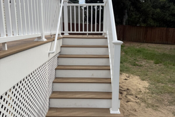 Composite deck stairs with white vinyl railing and ADA grab rail