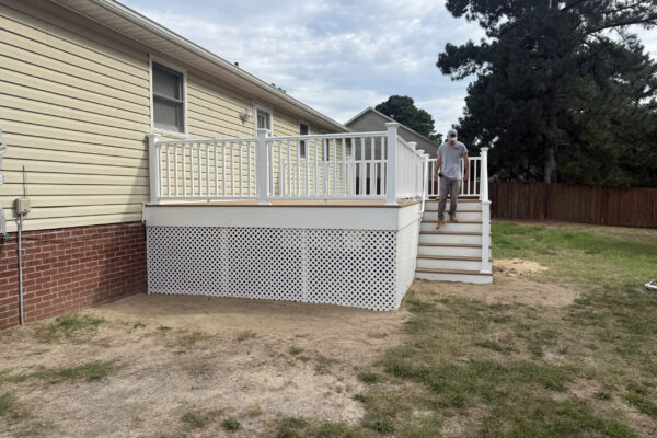 Kyle Speese walking down the stairs of a custom Trex Golden Hour composite deck built by Titan Decks in Cameron, NC.
