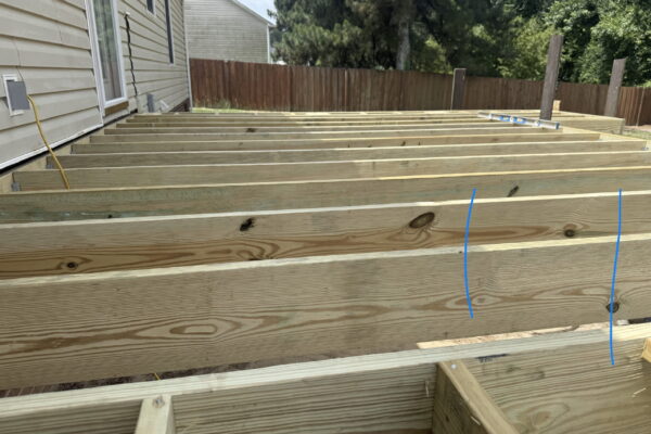 Pressure-treated deck framing before composite decking installation