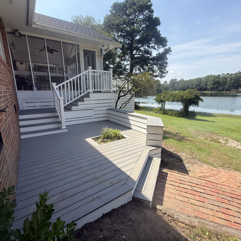 Resurfaced composite deck with built-in bench and lake view in North Carolina
