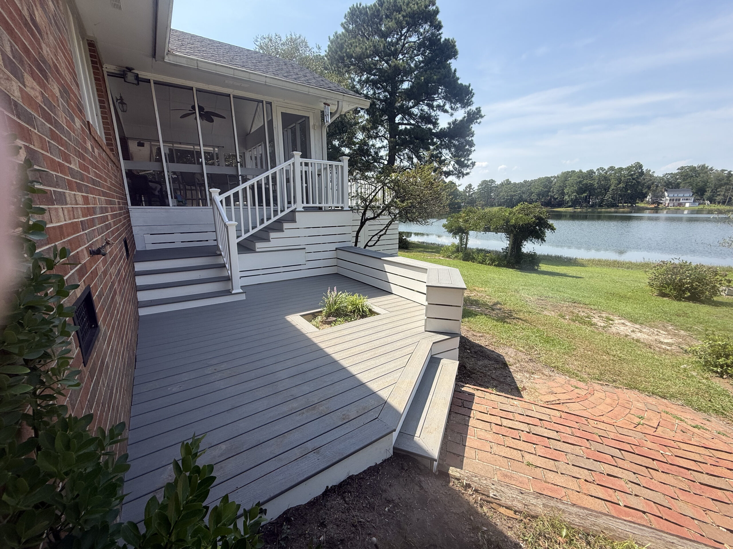 Resurfaced composite deck with built-in bench and lake view in North Carolina
